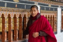 Buddhist monk spinning prayer wheels at the Tashichho Dzong (administrative and religious center) in Thimphu, Western Bhutan