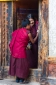 Young monk and old lady at the door of the temple, Jakar, Bumthang, Central Bhutan