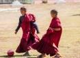 Novice Buddhist monks at Chimi Lhakhang near Punakha in Western Bhutan playing soccer during a break from studies