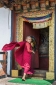 Young novice Buddhist monk entering Chimi Lhakhang (temple) near Punakha, Western Bhutan
