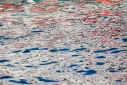 White on blue with red abstract reflections in a Venetian canal