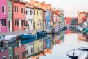 Colorful houses reflected in a still Burano canal, Veneto