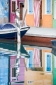 Boat and buildings reflected in a still Burano canal, Veneto