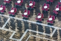 Raspberry chairs and white tables sit above reflected buildings in St. Mark's Square, Venice