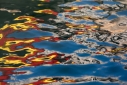 Bright red and yellow on blue abstract reflections in the Grand Canal in Venice