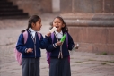 Schoolgirls share icecream in the main square in Cusco, Peru