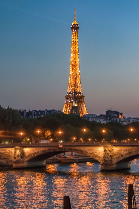 Eiffel Tower lit up, seen at night across the Seine, Paris, France