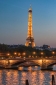Eiffel Tower lit up, seen at night across the Seine, Paris, France