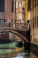 Gondolier on bridge over canal in Venice