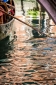 Gondola and oar on canal with reflections in Venice