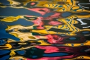 Abstract reflections in red, yellow and blue in Venetian canal