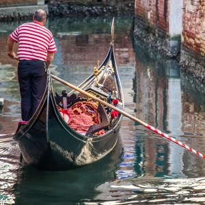 Gondola and gondolier on canal in Venice, horizontal