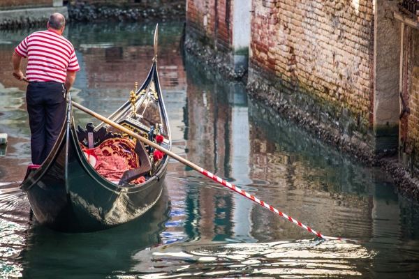 Gondola and gondolier on canal in Venice, horizontal