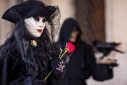 Masked woman with rose and man with crow during Carnavale, Venice